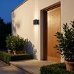 Verano wall light beside a front door at dusk