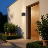Verano wall light beside a front door at dusk